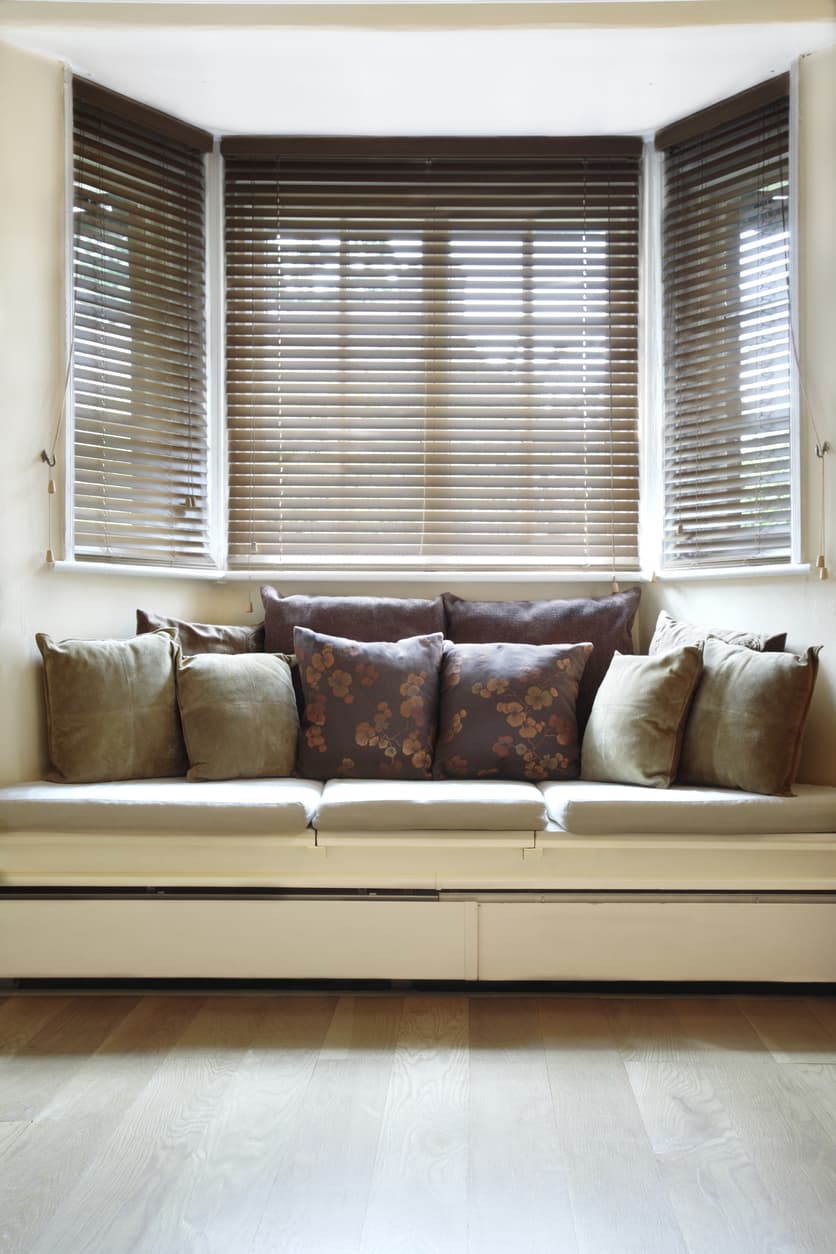 Bay window seat with pillows and blinds