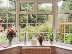 Bay windows in living room with flowers on window ledge